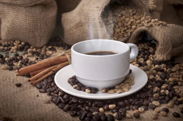 Kaffekopp och fat på ett träbord. Mörk bakgrund. — Stockfoto