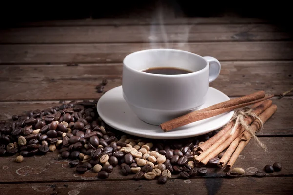 Kubek kawy i spodek na drewnianym stole. Ciemne tło. — Zdjęcie stockowe