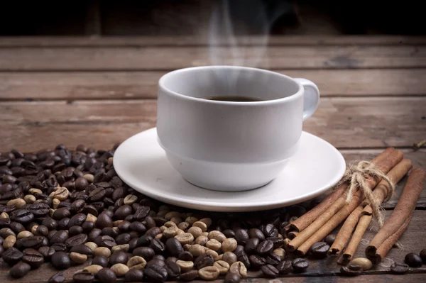 咖啡杯和茶托放在木制桌子上.黑暗背景. — 图库照片