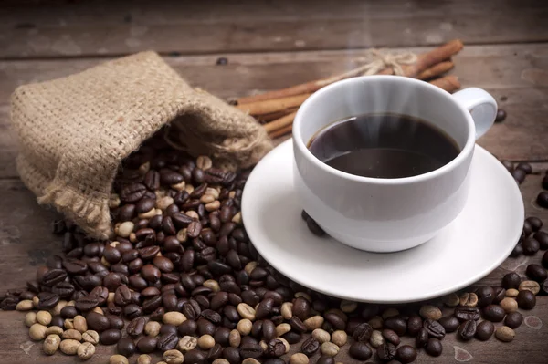 Kaffekopp och fat på ett träbord. Mörk bakgrund. — Stockfoto