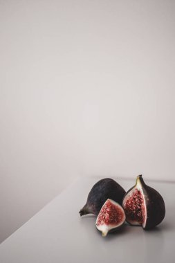 Olgun incir minimalizmi. İki parçada bir incir. Masada taze incir