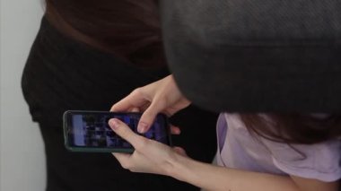 Genç bir kadının vejetaryen videosu evdeki kanepede uzanıyor ve telefonunu kullanıyor.. 