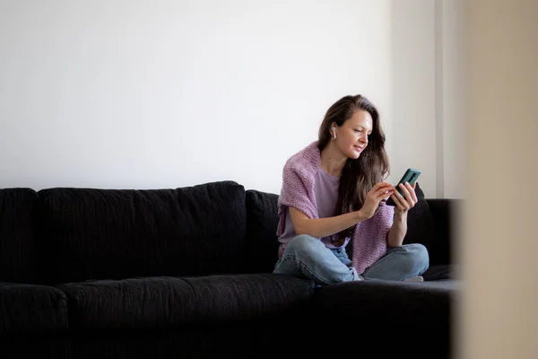 Ung Kvinna Hörlurar Använder Sin Telefon För Sociala Medier Och — Stockfoto