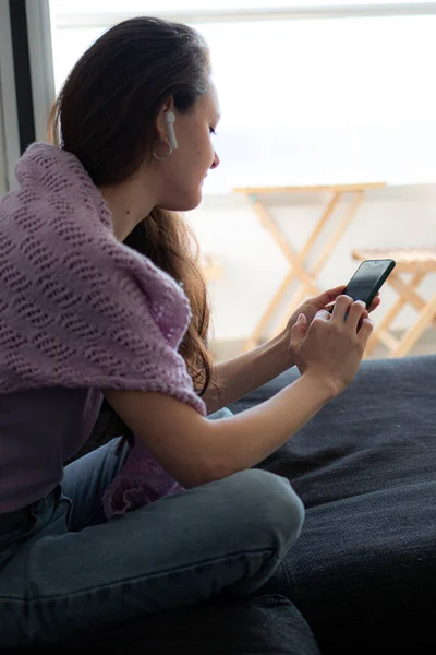 Young Woman Headphones Sitting Couch Sofa Home Using Her Phone — Stock Photo, Image