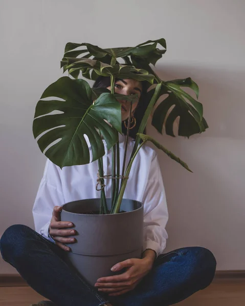 Seorang Wanita Muda Duduk Dengan Pot Bunga Besar Dengan Monstera — Stok Foto