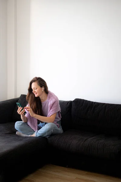 Young Woman Headphones Sitting Couch Sofa Home Using Her Phone — Stock Photo, Image