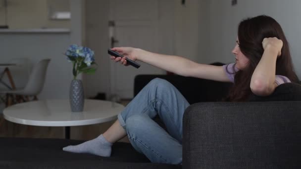 Eine Gelangweilte Frau Schaltet Hause Den Fernseher Aus Und Nimmt — Stockvideo