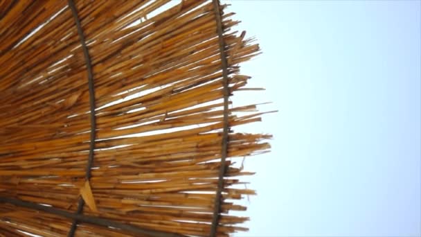 天空背景下的稻草海滩伞的顶部视图 — 图库视频影像