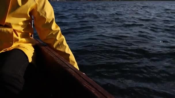 Junge Frau sitzt auf Holzboot im See und berührt Wasser — Stockvideo