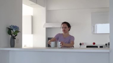 Genç bir kadın mutfakta iki kişilik çay yapıyor.