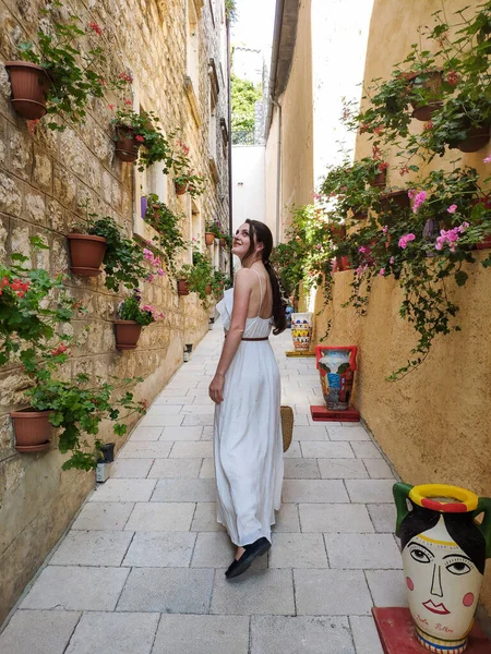 Karadağ 'ın Perast kentindeki taştan binalarla küçük bir sokakta yürüyen bir kadın