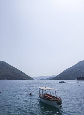 Karadağ 'ın Perast kentinde bir yaz günü tekneyle güzel bir deniz ve dağ manzarası