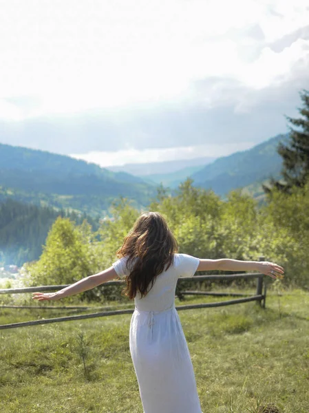 Sahada mutlu genç bir kadın dönüyor. Dağlarda özgürlük hissi