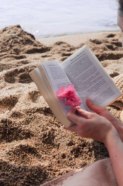 Plaj yatağı. Çakıl taşlı plajda kamış şemsiyeli güneşlikler. Şapka, çanta ve gözlükler.. 