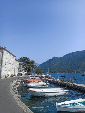 Karadağ 'ın eski Perast kentindeki kayık, deniz ve dağlarla dolu gündüz şehirleri