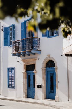 Kıbrıs Rum Kesimi 'nin Larnaka kentinde mavi kapı ve pencereli güzel bir bina.