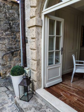 Karadağ 'ın eski Perast kentindeki bitkiler ve fener gibi beyaz detayları olan güzel bir restoranın yan görüntüsü