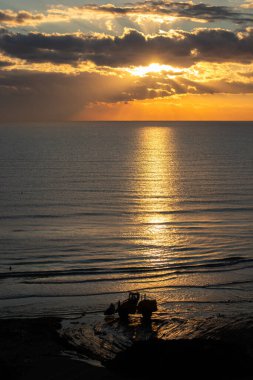 Kıbrıs 'ın Larnaka kentinde deniz kenarında çalışan bir traktör siluetiyle güzel bir gün doğumu.