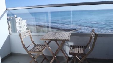 Cozy place on the balcony with a sea background. Person shows beautiful sea vide from the terrace