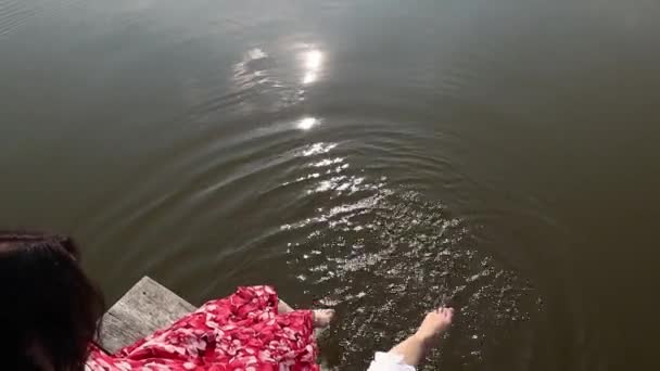 Two Barefoot Women Dress Waving Feet Lake Water While Sitting — Video Stock