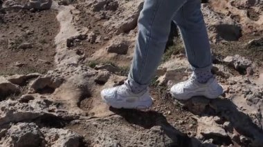 Close up of woman feet walking in a desert ground near the mountain Cape Greco in Ayia Napa, Cyprus. 