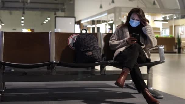 Mladá Žena Lékařské Masce Sedí Hale Letišti Dívá Telefonu — Stock video