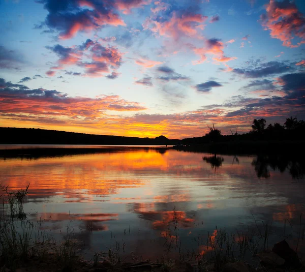 Markanter Sonnenuntergang über dem See mit hellen Wolken und Himmel — Stockfoto