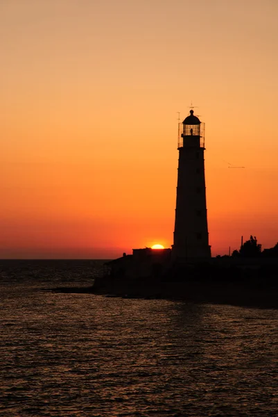 Puesta de sol de mar brillante sobre la torre del faro — Foto de Stock