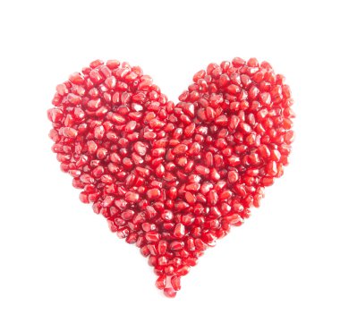 Olgun nar taneleri üzerinde beyaz backgr izole kalp şeklinde