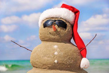kum gökyüzü karşı yapılmış bir kardan adam. Noel kavramı.
