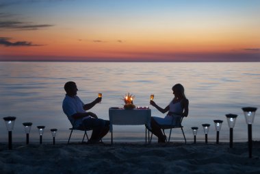 genç bir çift mum ve şarap gla ile romantik bir akşam yemeği paylaşmak