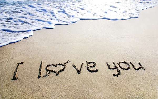 Parole "ti amo" contorno sulla sabbia bagnata con l'onda brillia — Foto Stock