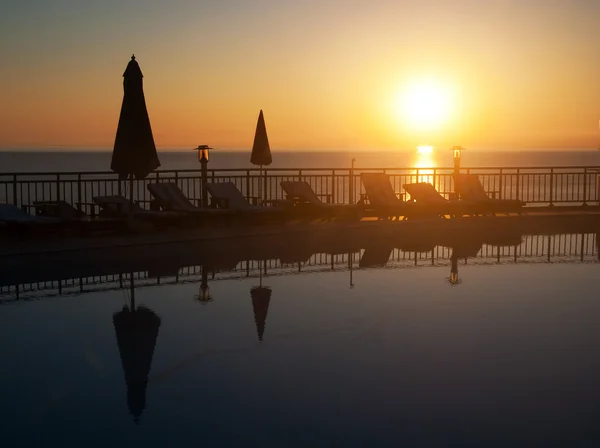 Mer plage station piscine contre le lever du soleil lumineux sous le — Photo