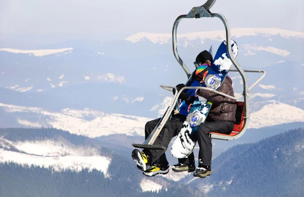 Skiers couple on a ski lift — Stock Photo, Image