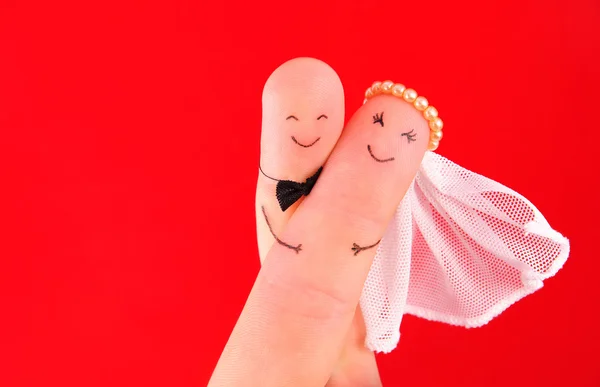 Just married couple - newlyweds painted at fingers against red b — Stock Photo, Image