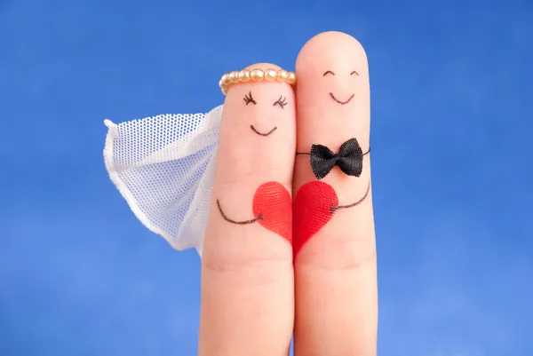 Concepto de boda - recién casados pintados con los dedos contra el cielo azul — Foto de Stock