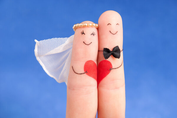 свадебная концепция - молодожёны, раскрашенные пальцами на фоне голубого неба
