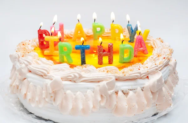 Gâteau d'anniversaire appétissant avec la lumière arc-en-ciel lettre bougies w — Photo