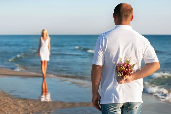 Liefdevol paar - man met bloemboeket wachten zijn vrouw op de — Stockfoto