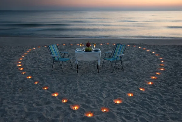 Jantar romântico na praia do mar com coração de vela — Fotografia de Stock