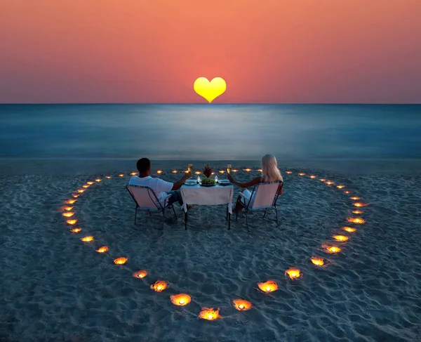 genç bir çift, kumsalda romantik bir akşam yemeği paylaşmak