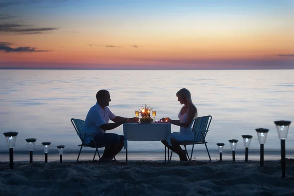 Um jovem casal compartilha um jantar romântico com velas e vinho gla — Fotografia de Stock