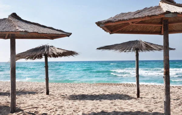 Praia de mar tropical puro com os guarda-chuvas de praia de palha — Fotografia de Stock