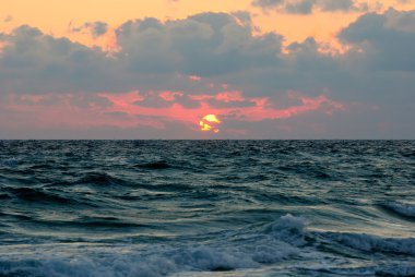 Deniz dalgaları yüzeyin altında bulutlu gün batımı panorama