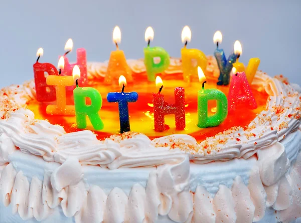 Gâteau d'anniversaire appétissant avec la lumière arc-en-ciel lettre bougies w — Photo