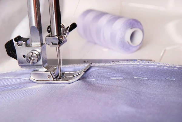 Processus de couture de tissu bleu sur la machine et deux bobines — Photo