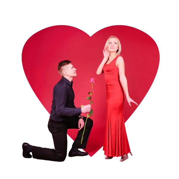 A man with rose flower and a woman against red background — Stock Photo, Image