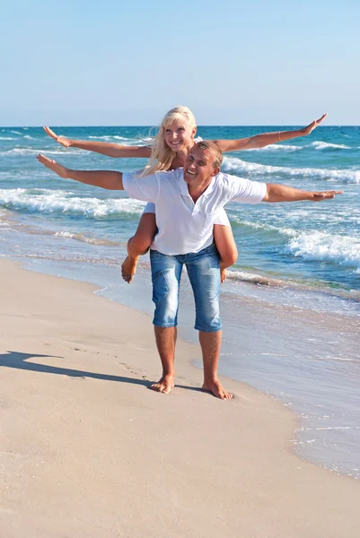 Pareja amorosa volando positivo en la playa del mar —  Fotos de Stock