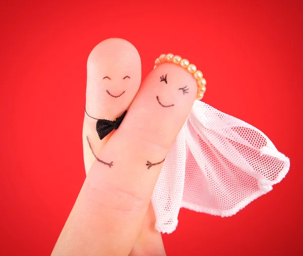 Just married couple - newlyweds painted at fingers against red b — Stock Photo, Image