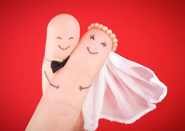 Hochzeitskonzept - Frischvermählte an Fingern gegen roten Rücken gemalt — Stockfoto